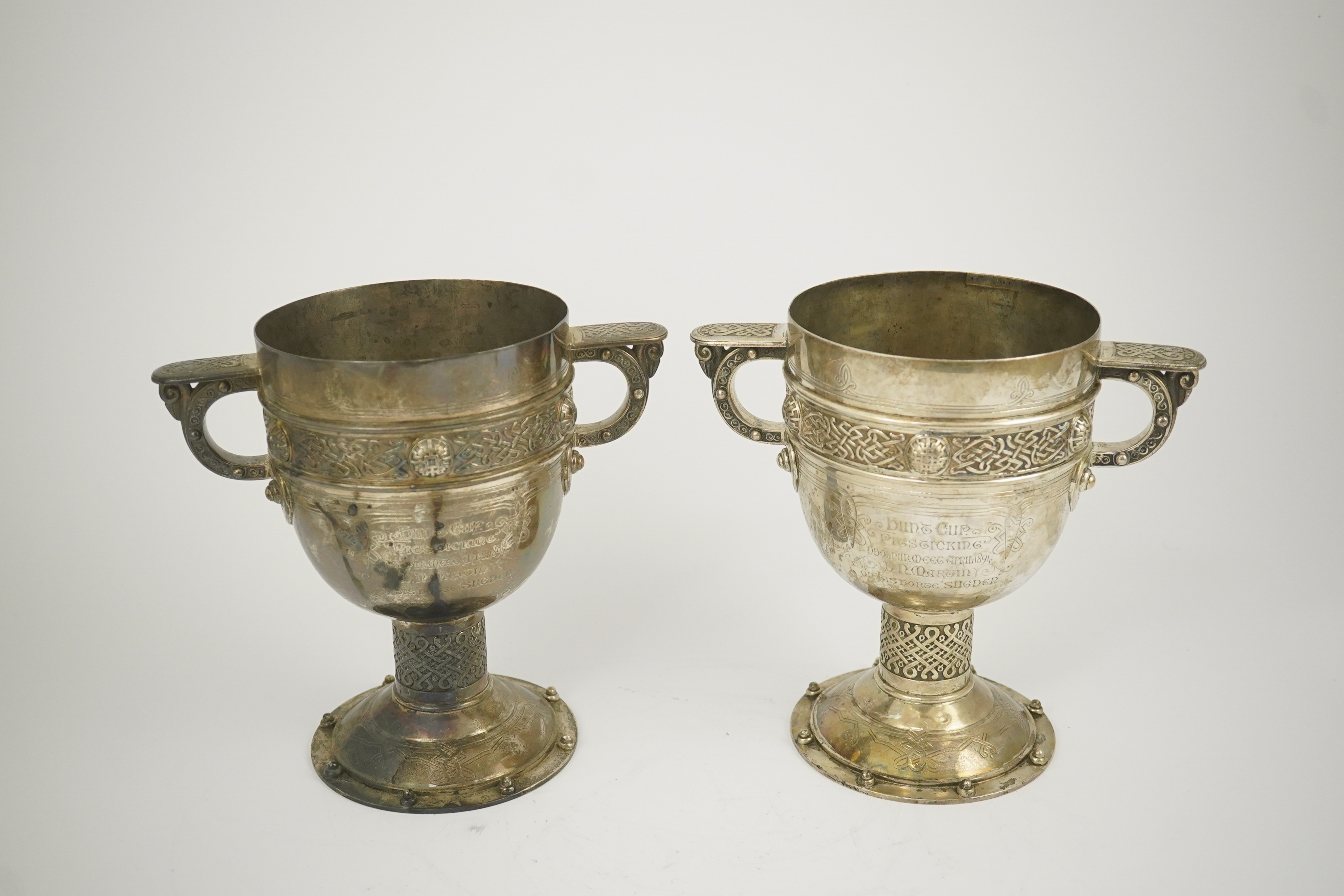 A pair of late Victorian Arts & Crafts Celtic style silver two handled presentation pedestal trophy cups, by Elkington & Co